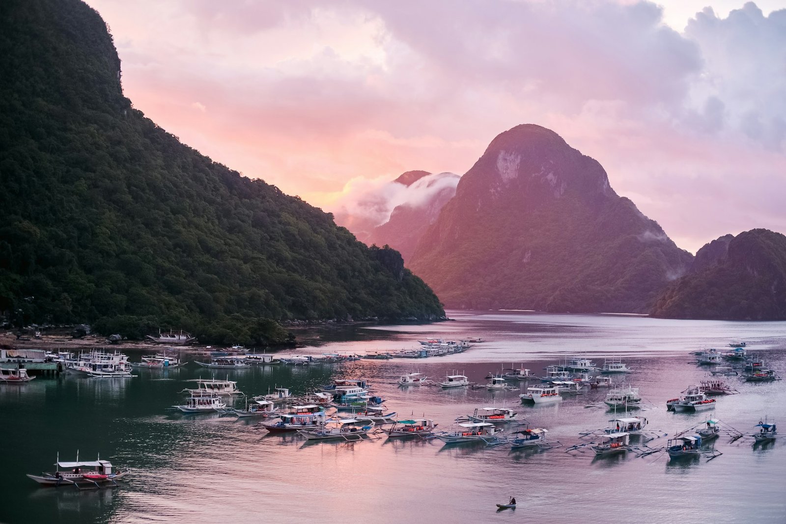 Atardecer sobre las islas de Palawan con barcos en la bahía, luna de miel en Filipinas