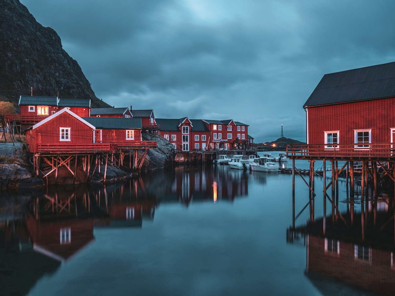 Pueblo de pescadores con cabañas rojas junto a una montaña en las islas Lofoten, luna de miel en Noruega
