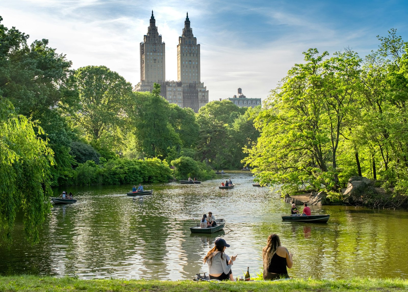 Pareja en barca en el lago de Central Park con los edificios de Manhattan al fondo, luna de miel en Nueva York